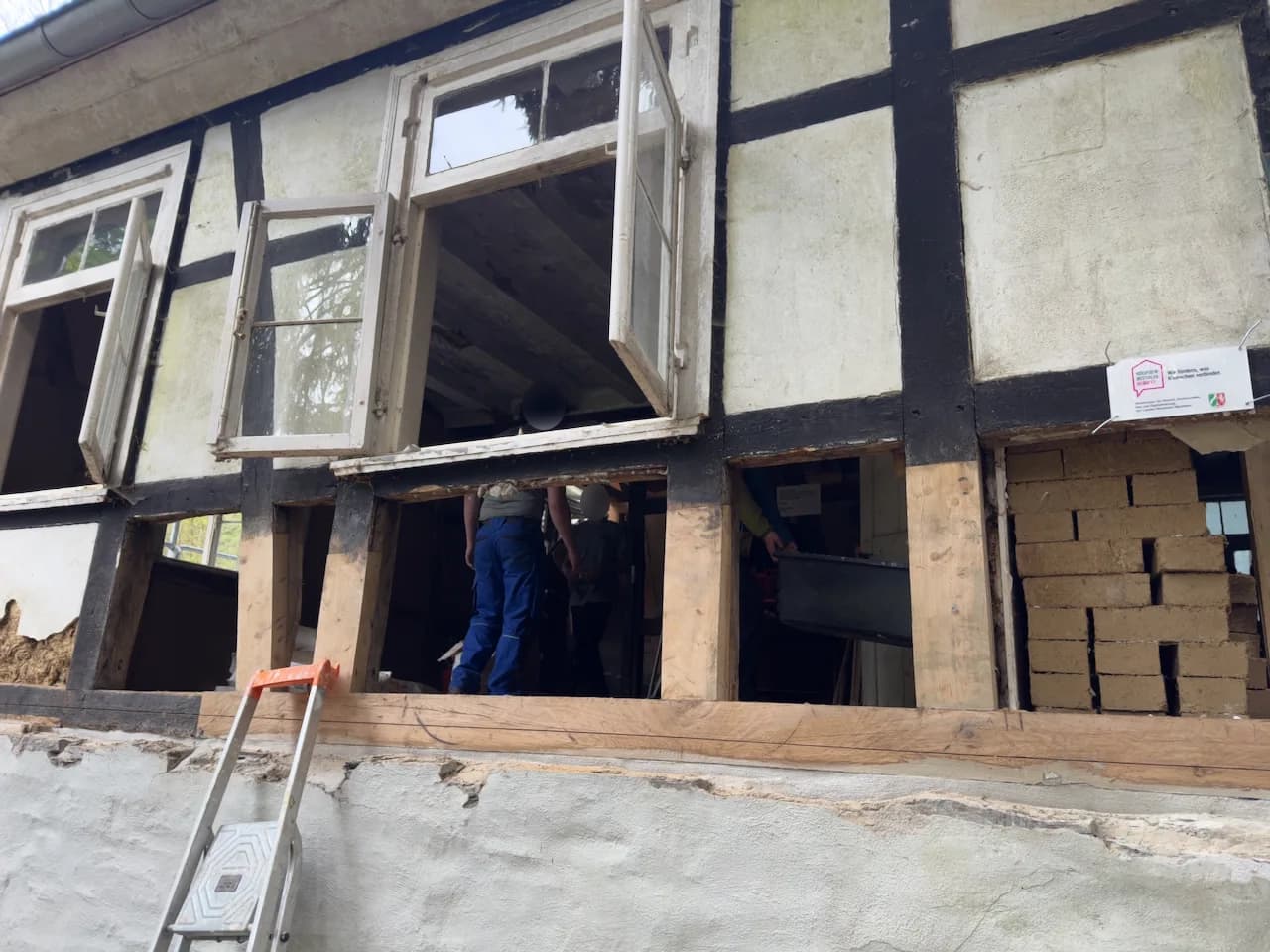 Fachwerkwand mit offenen Gefachen während des Ausmauerns.